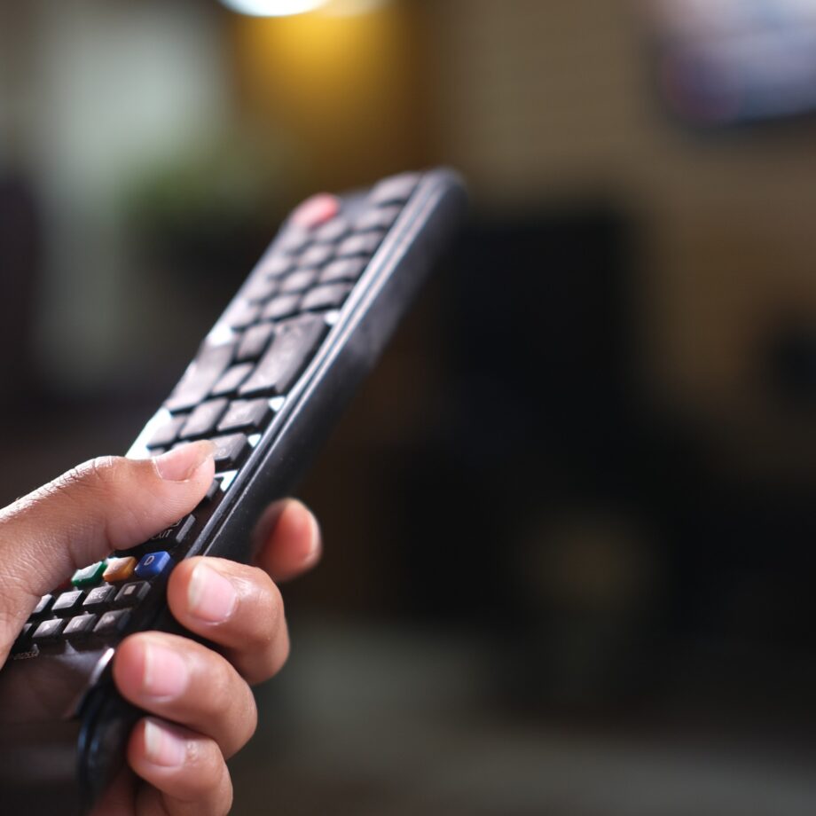 close up of man hand holding tv remote.