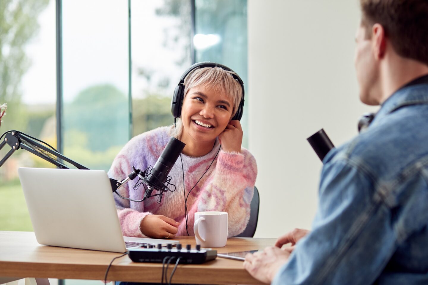 Couple Recording Podcast Or Broadcasting Interview On Radio In Studio At Home With Laptop