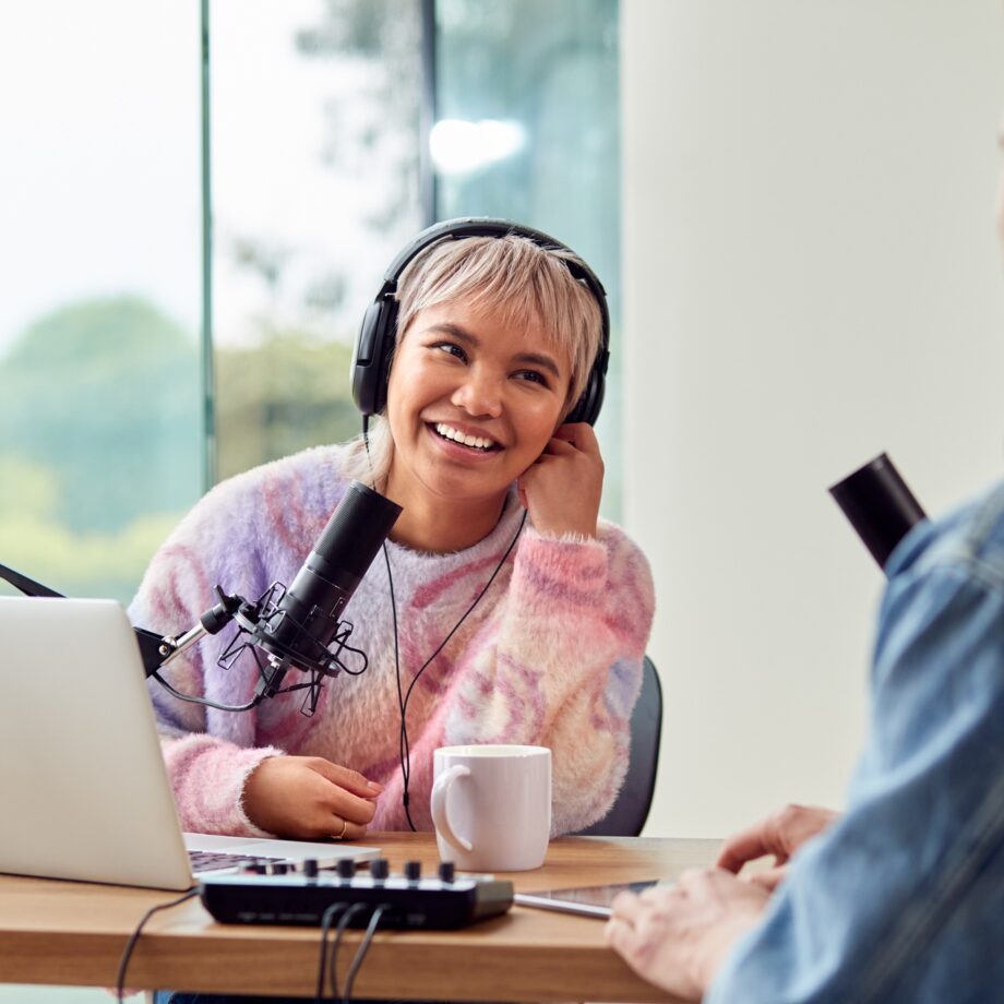 Couple Recording Podcast Or Broadcasting Interview On Radio In Studio At Home With Laptop