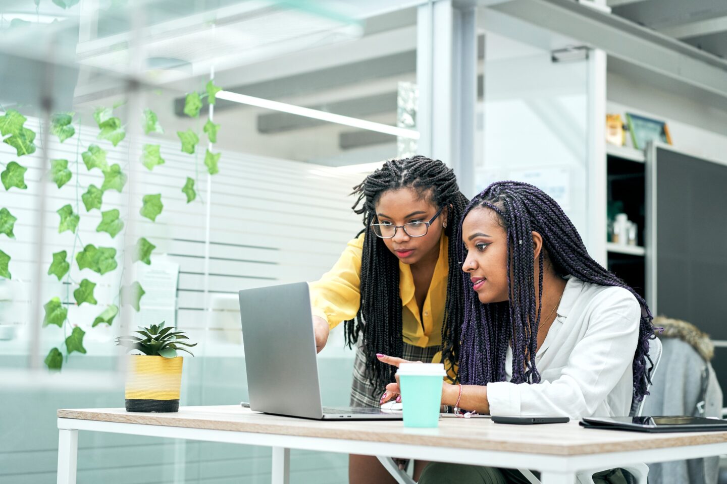 Female co-workers in the office discussing marketing strategies, reviewing analytical