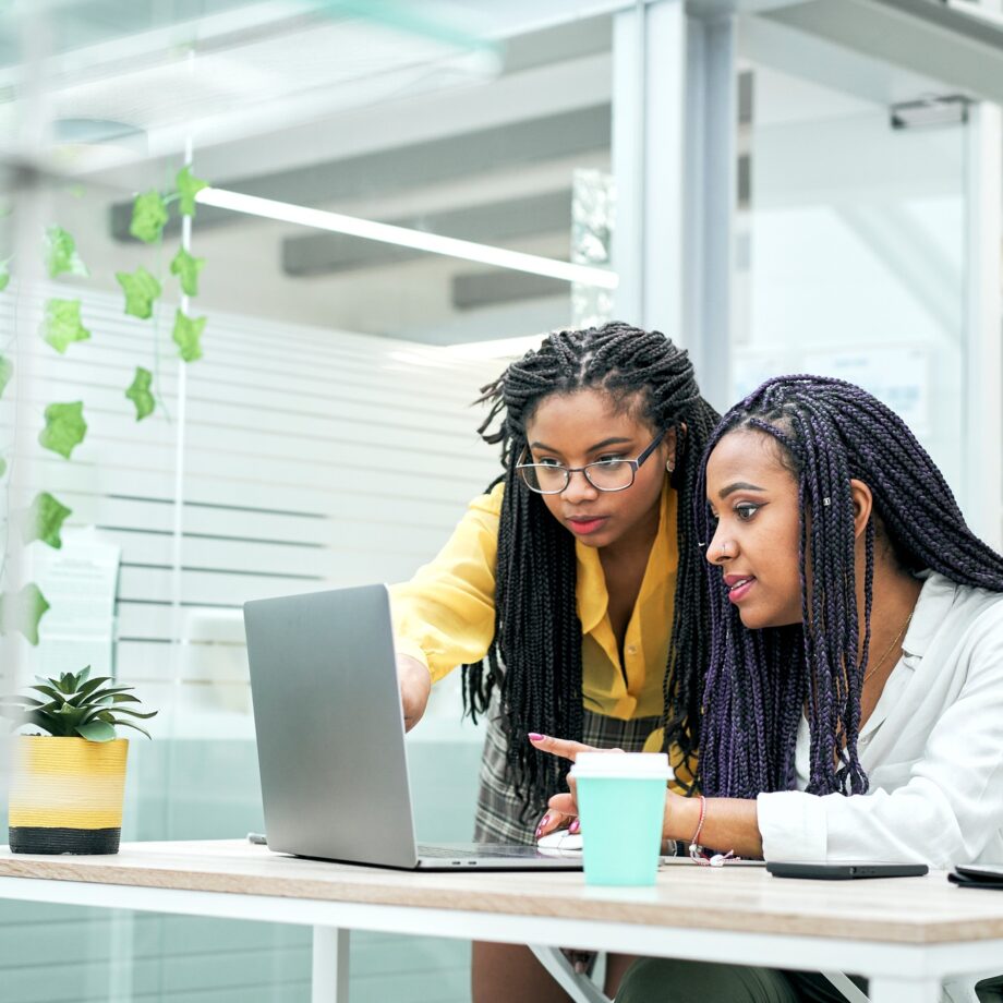 Female co-workers in the office discussing marketing strategies, reviewing analytical