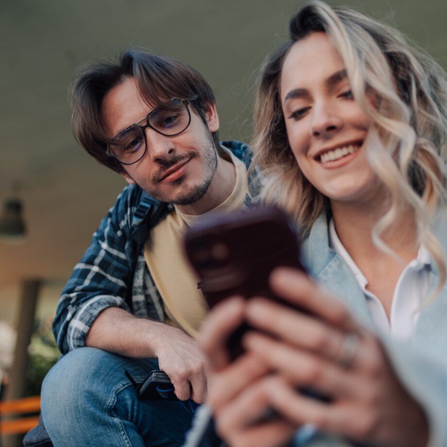 Students sharing social media content on smartphone outdoors