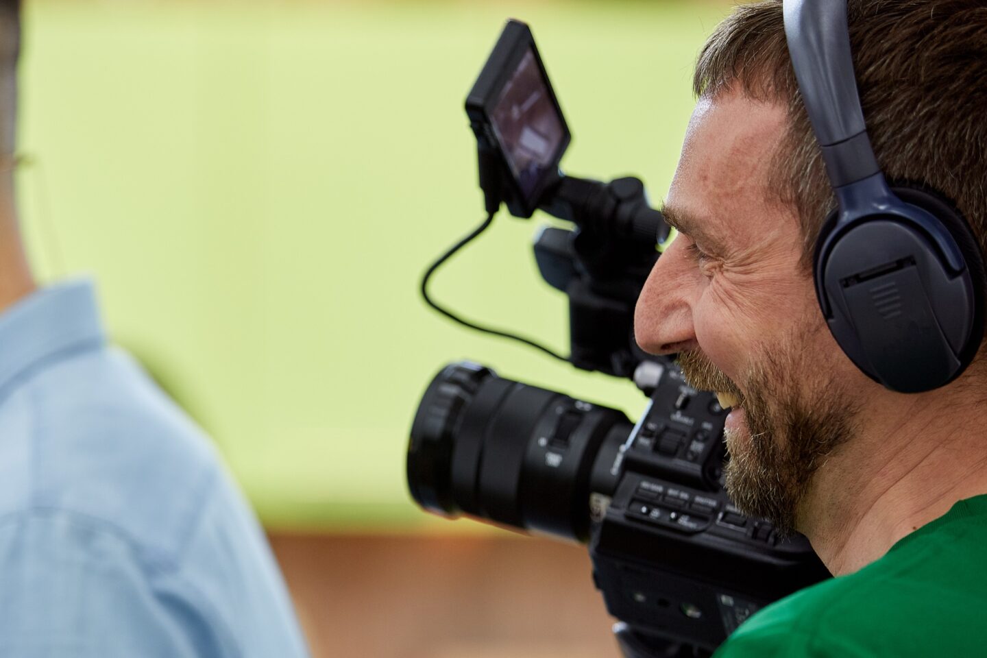 Videographer shooting a film or a television program in a studio with a professional camera