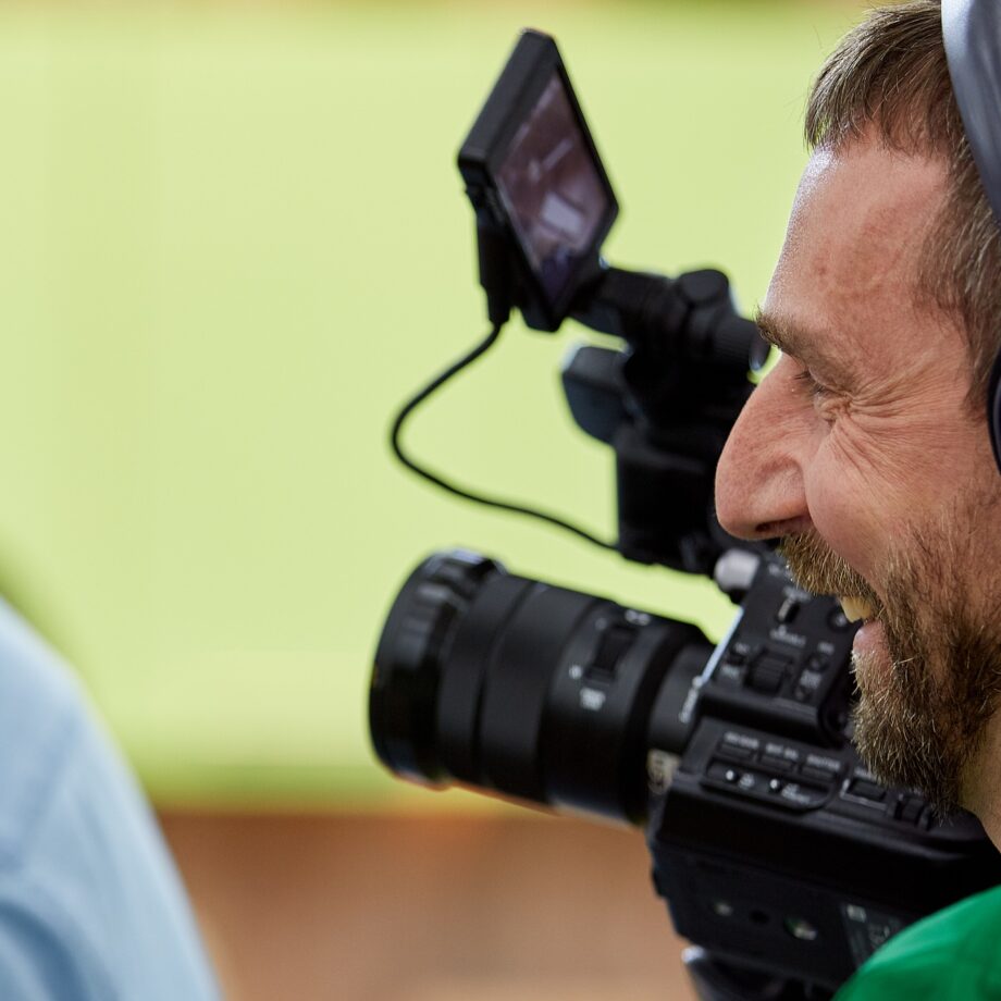 Videographer shooting a film or a television program in a studio with a professional camera